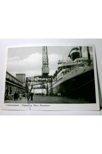 Schiffe. Bremerhaven. Columbusbahnhof. Alte Ansichtskarte / Postkarte s/w, gel. 1957. Bahnfofsgebäude, Dampfer am Pier, Ladekran, Personen.