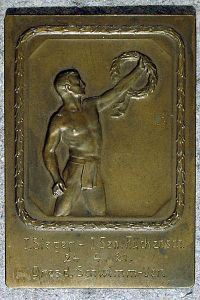 Bronze-Plakette: Antiker Athlet einen Lorbeerzweig haltend, floral umrandet.
